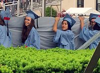 Companions of Emma Sulkowicz and the artist herself carrying the mattress to the graduation as a complaint