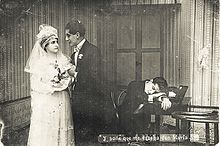 Black and white photo showing a newlywed couple on the left and a man asleep on a desk on the right.