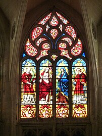 Glass colored with yellow silver stain surrounds and highlights the figures in a Flamboyant window at Toulouse Cathedral