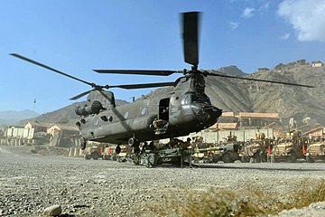 A CH-47 Chinook helicopter hooks up an M777 for sling loading.