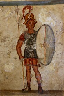 Fresco showing an upright soldier with chainmail armor and a shield.
