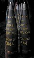 М107 артиљеријске гранате. Сви су означени тако да означавају пуњење "комп Б" (мешавина ТНТ-а и РДХ-а) и имају уграђене осигураче