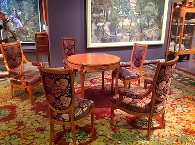 Mesa e cadeiras de Maurice Dufrene e tapete de Paul Follot no Salon des artistes décorateurs de 1912