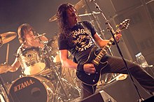 Close-up of Mario on drums and Joe Duplantier on guitar