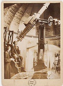 Un homme assis regarde dans un téléscope.