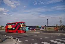 A route EL1 bus on the new Northgate Road extension passing the newly opened Barking Riverside pier in summer 2022.