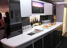 Airline premium economy galley bar. Drink bottles, glasses and bar snacks.