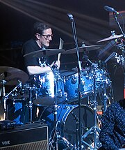 An older man playing a drum set
