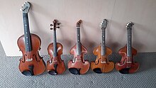 Four 120-year-old tenor violins with a full-size standard violin second from left for size reference.