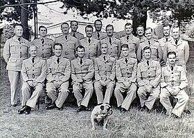 Formal portrait of Anderson seated with staff, students and bulldog mascot of the RAAF Staff School