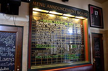 Blackboard with labels for names of train and destinations, but lists names of beers and other beverages instead