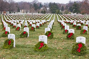 Thousands of balsam fir Christmas wreaths with red ribbons propped against headstones in Arlington National Cemetery in Arlington, Virginia, in the U.S.