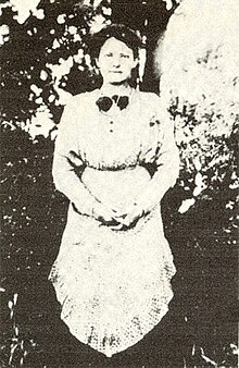 Young woman wearing an apron and facing forwards