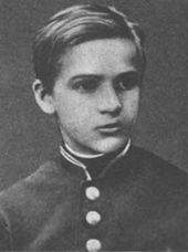 A black-and-white photograph of a young boy, looking towards the right