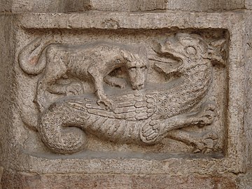 Uma serpe a lutar com um lobo, relevo, Catedral de Trento, Itália.