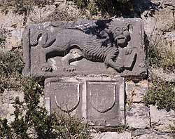Photo of reliefs of the Lion of Saint Mark and escutcheons built into a wall