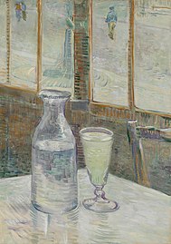 A glass and bottle on a café table
