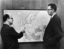 Side on view of Burson and Marstellar talking in front of map of Europe