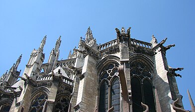Les puissants contreforts de la grande chapelle axiale sont surmontés de statues de rois musiciens. À gauche les deux ailes d'un arc-boutant du chevet.