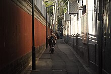 A woman riding a battery car in an alley