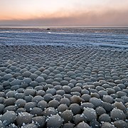 Ice eggs gain spherical symmetry by being rolled about by wind and currents.