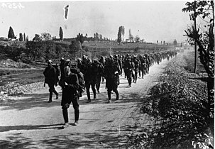Soldiers marching down a road
