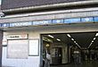A brown-bricked building with a rectangular, light blue sign reading "STOCKWELL STATION" in white letters all under a light blue sky