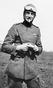Three-quarters portrait of aviator with raised goggles in military uniform