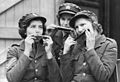激務の合間にハーモニカを吹いて息抜きするATSの女性兵士。第二次大戦初期。