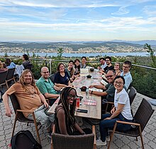 The Abstract Wikipedia team at a 2022 offsite in Switzerland. Left hand side on the table, from front to back: Ariel Gutman, Ori Livneh, Maria Keet, Sandy Woodruff, Mary Yang, Eunice Moon. At head of table: Rebecca Wambua. Right hand side of the table, from front to back: Olivia Zhang, Denny Vrandečić, Edmund Wright, Dani de Waal, Ali Assaf, James Forrester.