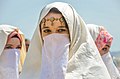 نساء في الجزائر يرتدين الحايك، وهو نوع من الحجاب.