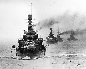 A formidable line of warships with big guns heads straight toward you, trailing smoke