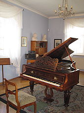 Room in old house with grand piano in the centre