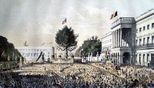 Lithographie colorée représentant les décorations de la place des Palais à l'occasion des 25 ans de l'inauguration de sa majesté le Roi Léopold Ier. Une foule de belges se tient devant le Palais royal.
