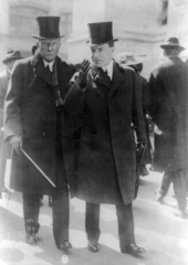 An image of John D. Rockefeller and John D. Rockefeller Jr. walking down a street.
