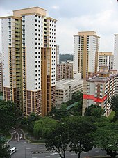 High-rise buildings stand next to each other besides a road. An apartment unit of the block on the right is highlighted in red.