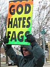 מפגין הומופוב נושא שלט עליו כתוב "אלוהים שונא מתרוממים"