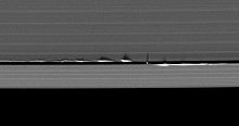 « Vagues » verticales provoquées par Daphnis projetant leurs ombres dans les anneaux de Saturne.