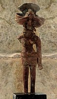 Mother Goddess wearing tight-fitted short skirt part fastened with a broad waistband using a medallion like clasp, necklaces, ear-ornaments, Mohenjo-daro,