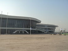 partial view of a curvy white building with long airport-style windows