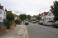 A wide suburban street with semi-detached housing