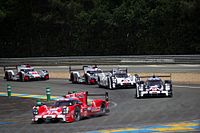 Os três carros da Porsche no final da reta de Mulsanne seguidos pelos Audi R18 e-tron quattro durante as 24 Horas de Le Mans de 2015, na França.