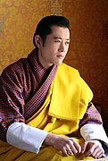 Jigme Khesar Namgyel Wangchuck, the fifth King of Bhutan, wearing a gho and royal saffron kabney, c. 2007
