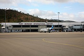 Airport terminal building with twin-engined jet parked in front