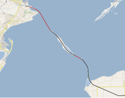Trasa nového mostu na mapě Kerčského průlivu. Černě jsou znázorněny části mostu stojící na pevnině, červeně ty překlenující moře.