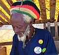 Image 1Picture of Rastaman in Barbados, wearing the Rastafari colours of green, gold, red and black on a rastacap.