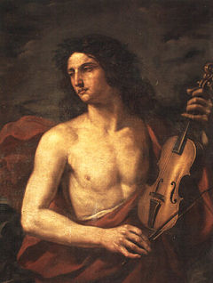 A young man with long flowing hair, bare chested, holds a stringed instrument in his left hand, while looking way to the left with a soulful expression
