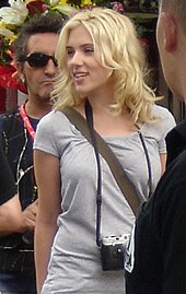 Scarlett Johansson with tousled medium length blonde hair loosely around her shoulders and face, looking to her right.