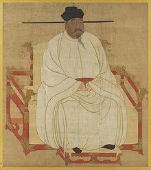 Malba tělnatého muže sedícího na červeném trůnu ozdobeném dračími hlavami, muž má na sobě bílé hedvábné šaty, černé boty a černou pokrývku hlavy, černý knír a bradku.