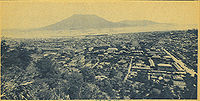 Mesto globoko v pepelu po izbruhu vulkana Sakurajima leta 1914, ki je viden v daljavi čez zaliv